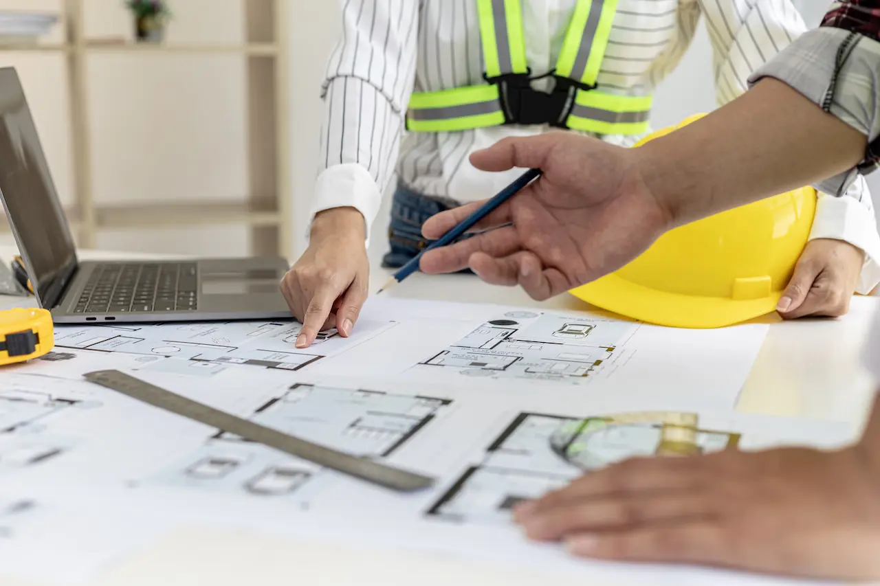 Two architect-engineers are consulting to modify the blueprints of the contracted house, they have a meeting to inspect the house designs before meeting with the client. Home design ideas.